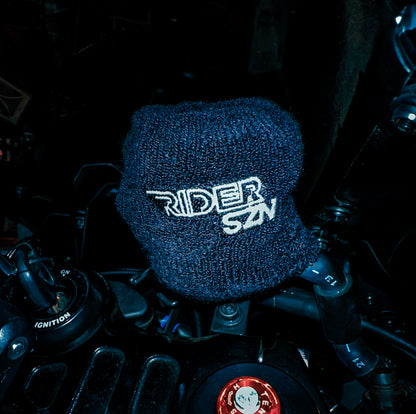 A black cotton terry brake reservoir sock with the text 'RIDER SZN' on it, placed on a motorcycle.
