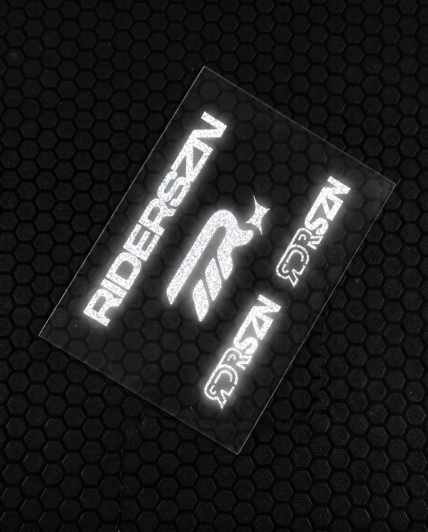 Reflective stickers with 'RIDERSZN' and RDRSZN logo on a textured black background