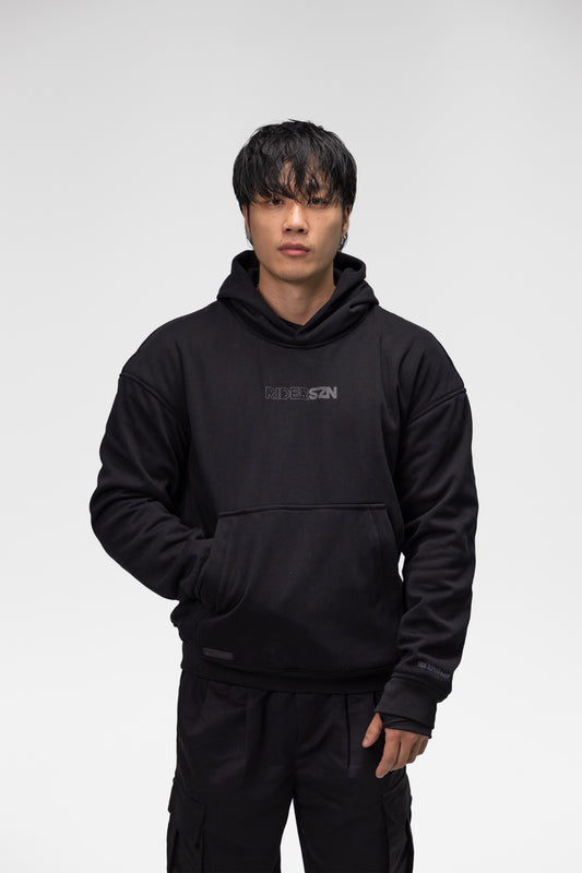 man wearing a black hoodie with a brand logo on a white background, front view