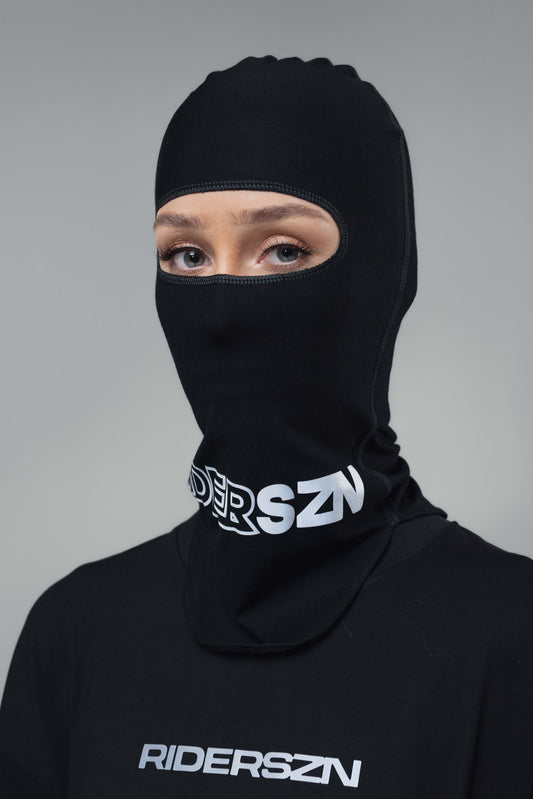 Person wearing a black soft seam balaclava with silver 'RiderSZN' branding front view.